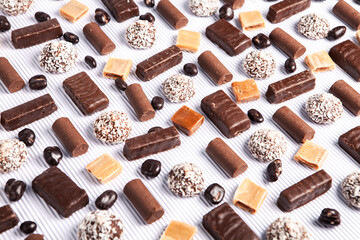 Assorted chocolate candies on wooden background. Chocolate sweets. Dessert background.
