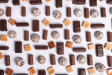 Assorted chocolate candies on wooden background. Chocolate sweets. Dessert background.