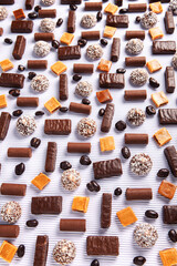 Assorted chocolate candies on wooden background. Chocolate sweets. Dessert background.