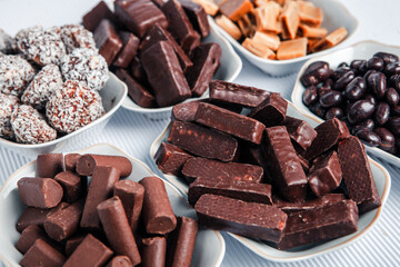 Assorted chocolate candies on wooden background. Chocolate sweets. Dessert background.