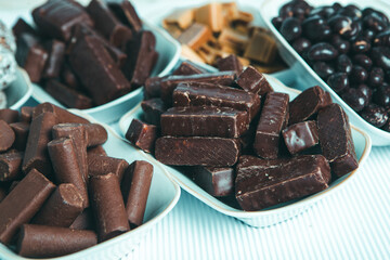 Assorted chocolate candies on wooden background. Chocolate sweets. Dessert background.
