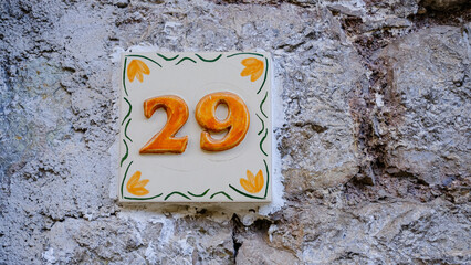 Ceramic house number on wall. number twenty-nine. 29