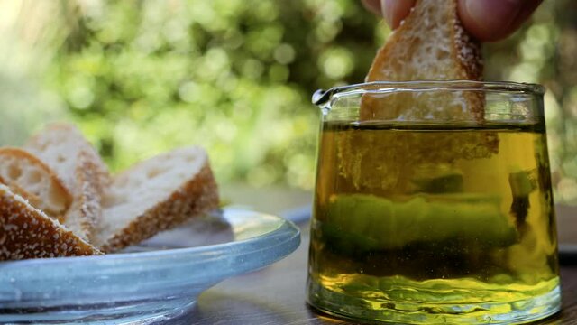 Eating bread with Moroccan organic cold-pressed Extra Virgin Olive Oil. Background footage healthy eating lifestyle. Slow motion footage.