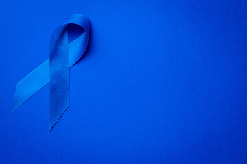 Blue ribbon. Awareness of men health in November with blue prostate cancer ribbon isolated on deep...