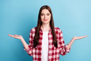 Photo of young charming happy woman hold hands empty space scales choose isolated on blue color background