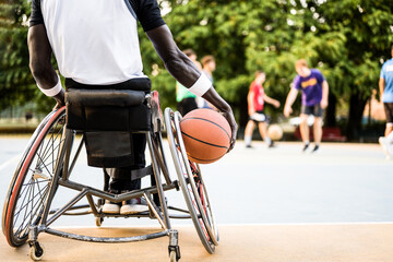 african american basketball player in wheelchair waiting to play on open air ground, concept of...