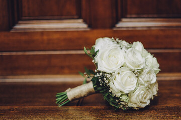 bridal bouquet of white roses on a wooden background