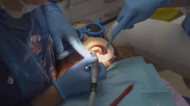 kid girl with oral dilator at dentist's appointment. treatment of teeth