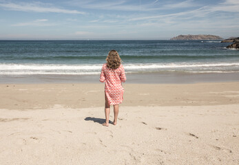 woman on a beach enjoying the sea view during a vacation