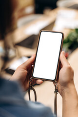 Young entrepreneur browsing site on cell phone indoors