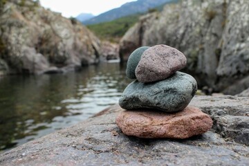Fototapeta na wymiar empilement de rochers au bord d'une rivière calme 
