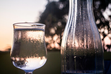 gouttes et condensation sur un verre et une bouteille au coucher de soleil