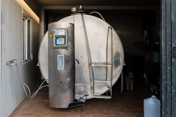 Milk cooling tank in a dairy farm. Milk storage and cooling. Dairy industry concept.