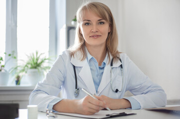 The doctor is in his office. Beautiful smart woman doctor is conducting a consultation. Remote medical consultation and telemedicine concept. Clinic work.