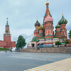 view from Red Square to the Kremlin Spasskaya Tower and St. Basil's Cathedral against the background of a cloudy sky. Moscow. Russia