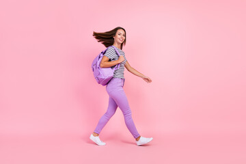 Photo of charming funny young woman dressed striped clothes rucksack walking wind blowing smiling...