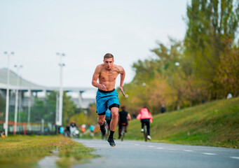 Young runner jogging on running track in park