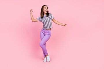 Fototapeta na wymiar Photo of cute charming young woman dressed striped clothes dancing smiling isolated pink color background