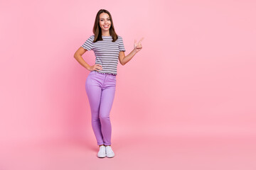 Fototapeta na wymiar Photo of pretty cute young woman dressed striped clothes pointing finger empty space smiling isolated pink color background