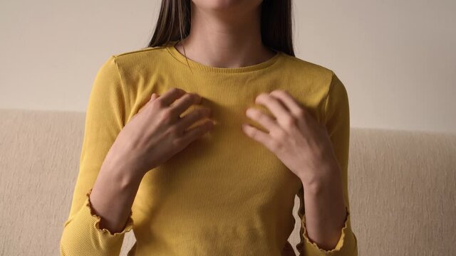 Young teenage girl practicing EFT or emotional freedom technique - tapping on the collarbone point, at home
