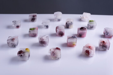 frozen fresh berries fruits in ice cubes on white background