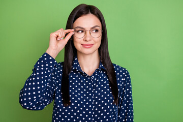 Photo of nice brunette hairdo intelligent lady look empty space wear spectacles blue shirt isolated on green color background