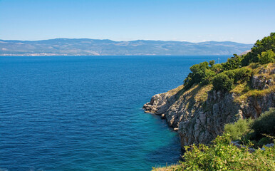 The late summer coastline near the hill village of Vrbnsk on Krk Island in Primorje-Gorski Kotar County in western Croatia. The Croatian mainland can be seen in the background
