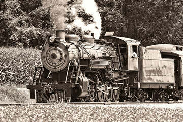 A Black and White View of an Antique Restored Steam Passenger Train Blowing Smoke and Steam on a Sunny Summer Day