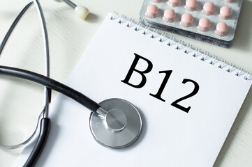 on the table a stethoscope, pills in plates and notepad with text b12, medical concept