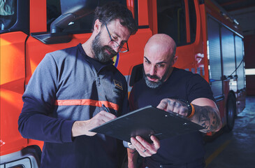 Fototapeta na wymiar Pair of firefighters standing planning and instructing. Teamwork concept