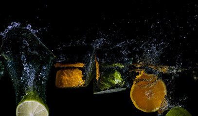 Bright juicy fruits on a dark background with a spectacular splash in wide high definition