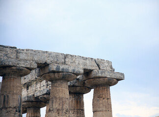 Detail of the node between the column and the lintel of the temple, against the cloudy sky, ...