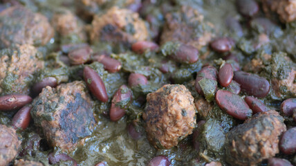 Close up of a Pkaila dish, also called bkaïla, bkeila, or pkela, a traditional Tunisian Jewish stew, made of beans and spinach leaves 