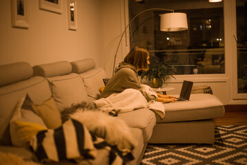 young woman working with the computer from the cocuh at home