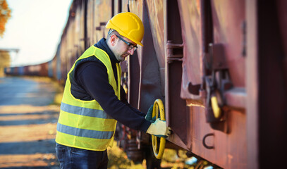 Safety first. Technician controls correctness of the freight car. Transportation concept