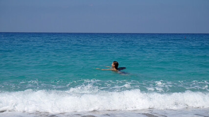 a girl swims in the blue sea