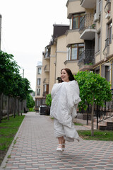 pretty brunette woman in white blanket outdoors. crazy rebel millennial girl