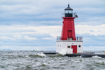 Fototapeta premium Menominee Pierhead Lighthouse at Ann Arbor Park, as choppy waves of Lake Michigan crash ashore