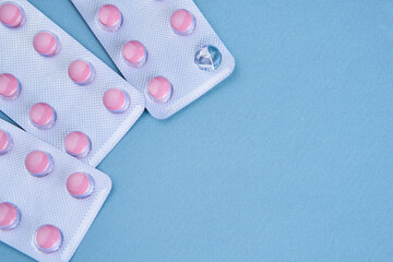 pink pills in packs vitamins pain reliever blue background