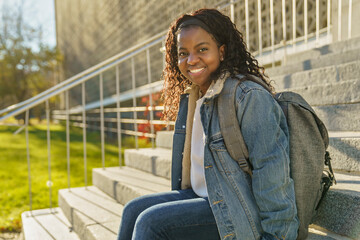 pretty african american woman with backpack at the park
