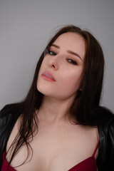 Naklejka premium young brunette woman in black leather jacket exhales white smoke. beautiful girl millenial on grey background smoking. bad habit