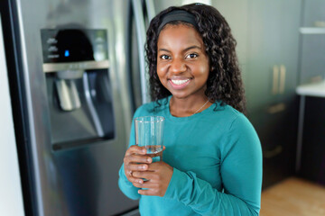 Young Woman on front of Fridge At Kitchen