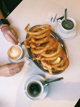 Overhead view of a woman enjoying Spanish churros with coffee