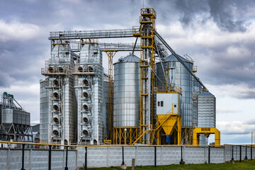 Fototapeta na wymiar modern granary elevator and seed cleaning line in silver silos on agro-processing and manufacturing plant for storage and processing drying cleaning of agricultural products, flour, cereals and grain