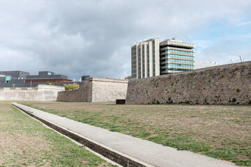 Old city walls with modern building behind.