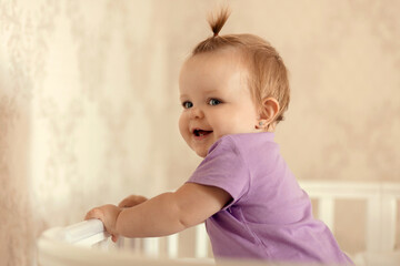 healthy baby playing and smiling in a crib