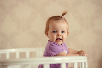 healthy baby playing and smiling in a crib