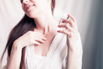 girl sprays herself perfume on her neck