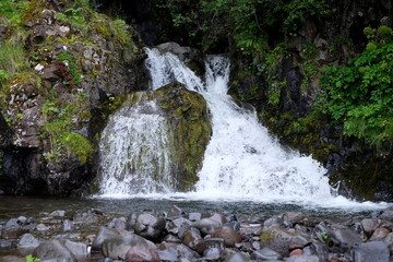 Small waterfall among stones and plants