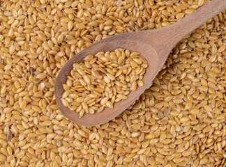 Closeup of golden linseed seeds on a wooden spoon